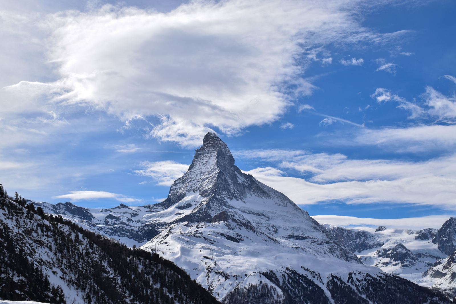 The snow-covered pyramid of the Matterhorn against a clear blue sky