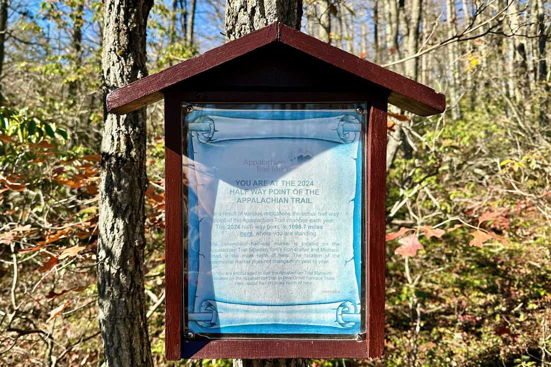 Wooden sign marking the halfway point of the Appalachian Trail in a Pennsylvania forest