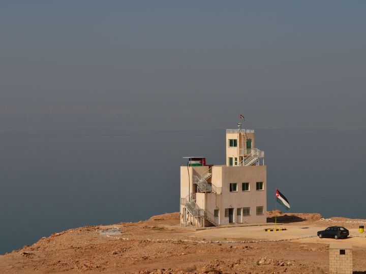 Calm Dead Sea water with salt deposits along the shore on the Jordanian side