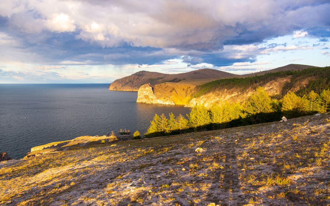 Rocky capes of Olkhon Island glowing at sunset above Lake Baikal
